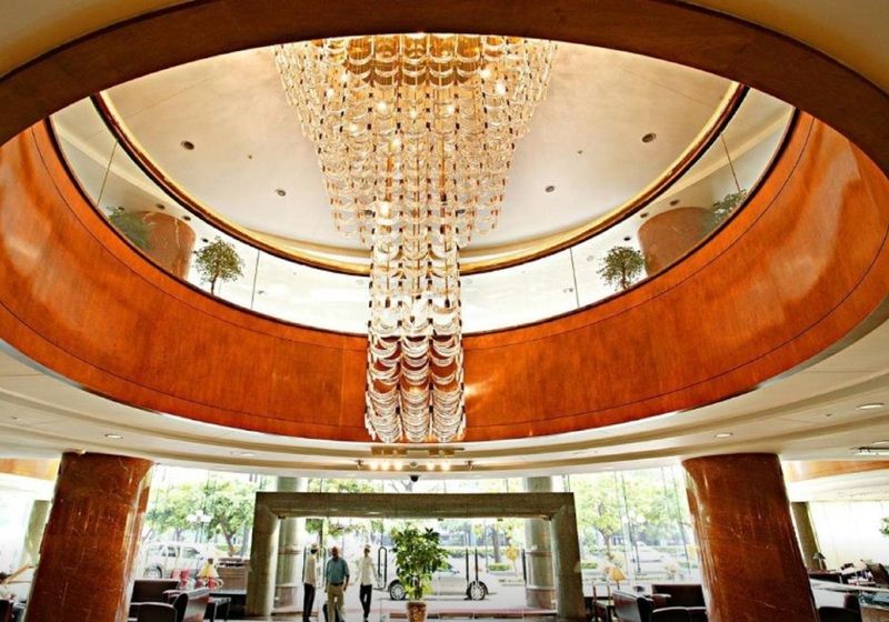 Evergreen Laurel Hotel - Taizhong Zewnętrze zdjęcie The photo shows the interior of a lobby, featuring a large, elegant chandelier hanging from a circular ceiling. The design incorporates warm wooden tones and modern architectural elements. The space is open and airy, with large glass windows allowing