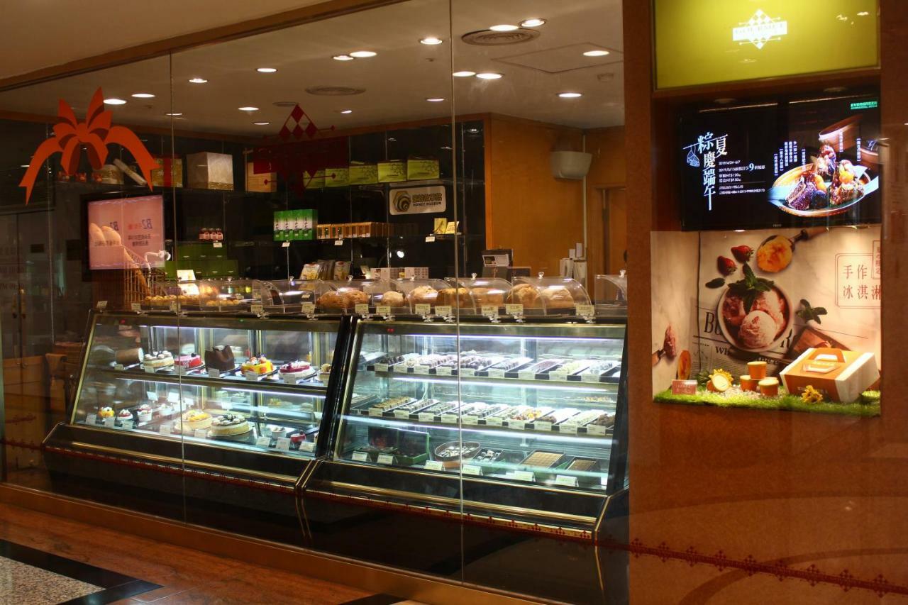 Evergreen Laurel Hotel - Taizhong Zewnętrze zdjęcie The photo shows a display case in a bakery or dessert shop. The glass case is filled with a variety of pastries, cakes, and desserts arranged neatly. Behind the display, there is a counter with additional items and desserts visible. The walls are dec